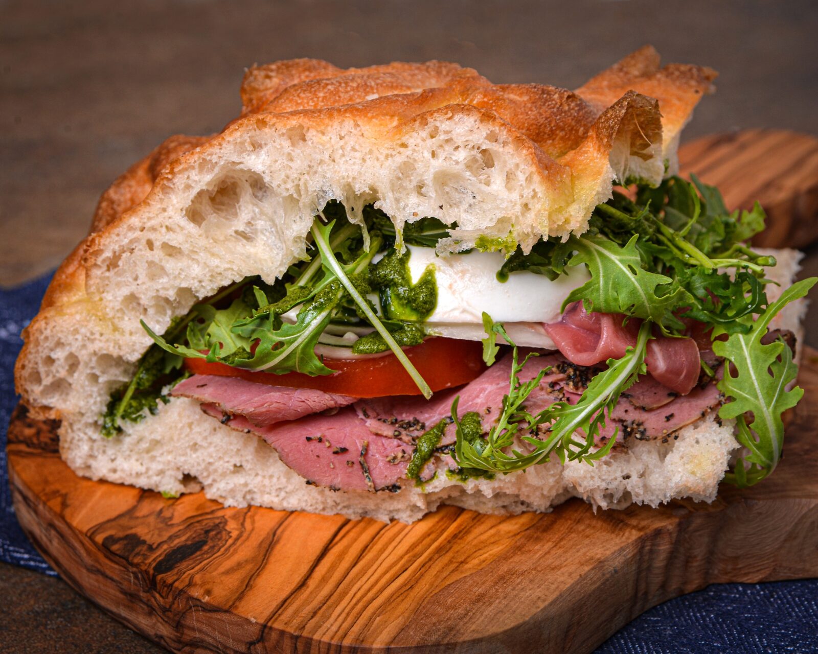 Freshly baked focaccia filled with pastrami, mozzarella, tomato, pesto and rocket at Smolenski’s Deli