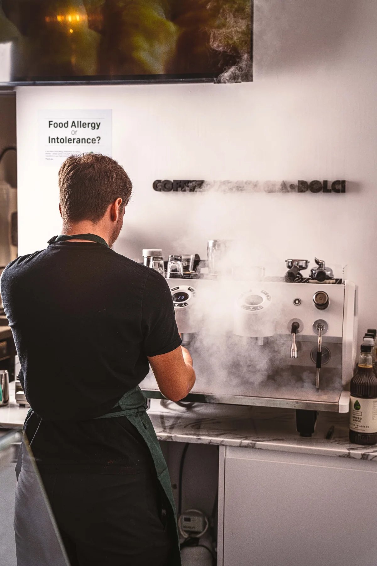 A Smolenski’s team member preparing coffee behind the counter
