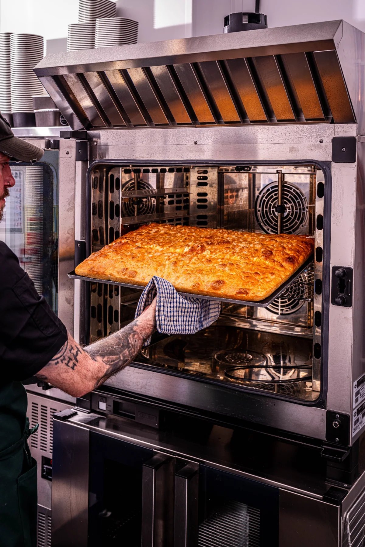 Freshly baked focaccia being lifted from the oven